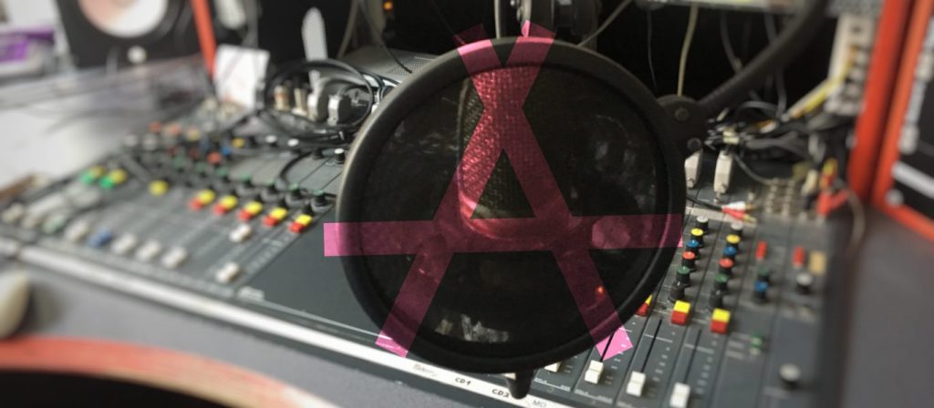 Mischpult mit Mikrophon und Anarchiesymbol