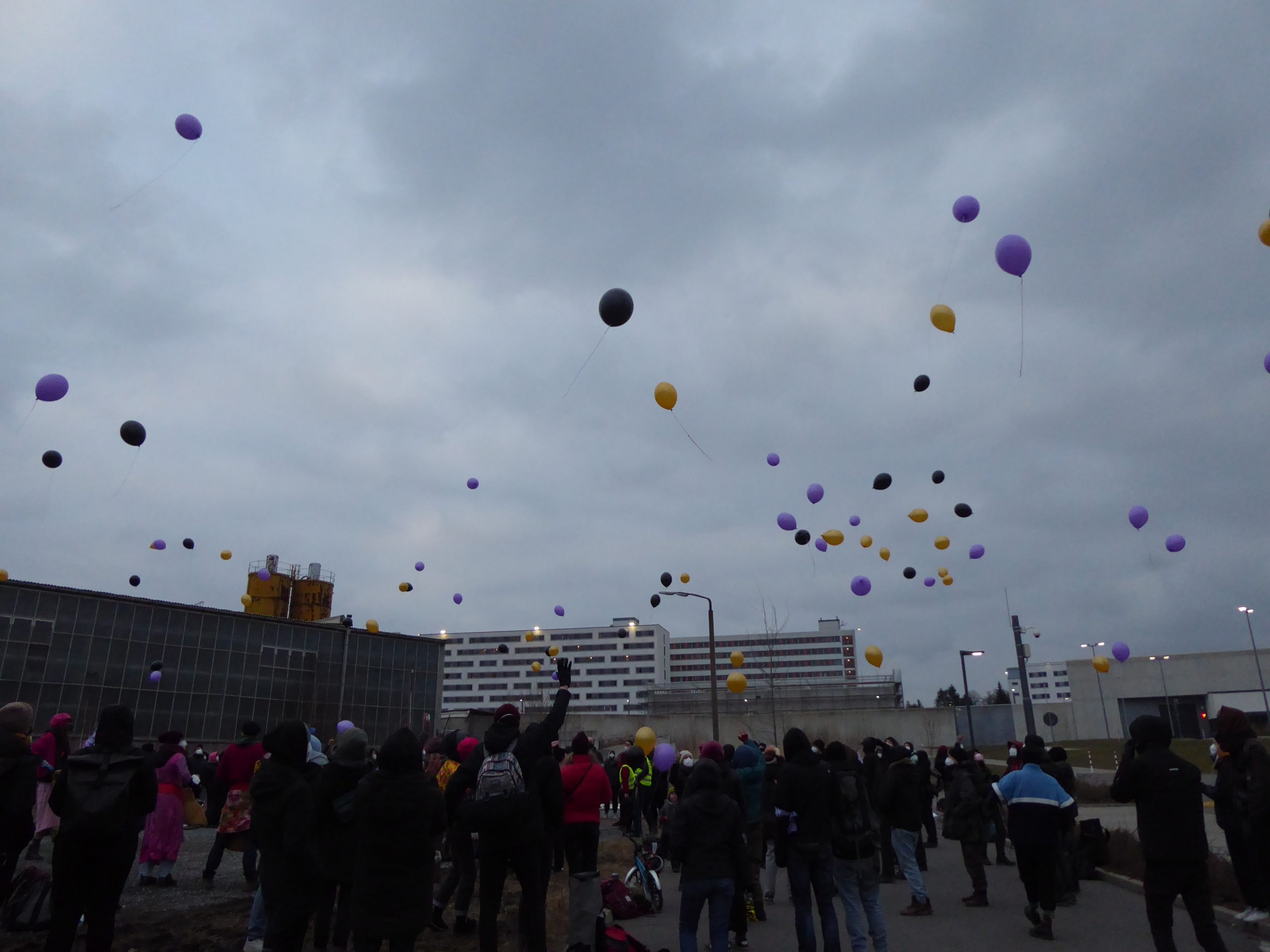 Menschen lassen vor der JVA Chemnitz Luftballons steigen